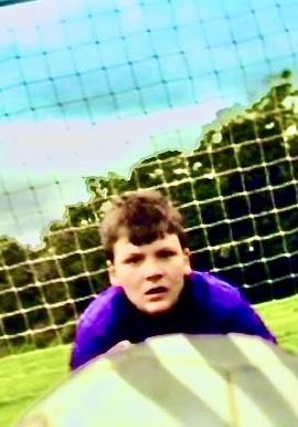 Boy defends football goal as a ball comes towards him