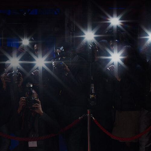 Image for CSFF Festival web banner. Flash bulbs sparkle in the dark behind the velvet rope on a red carpet.