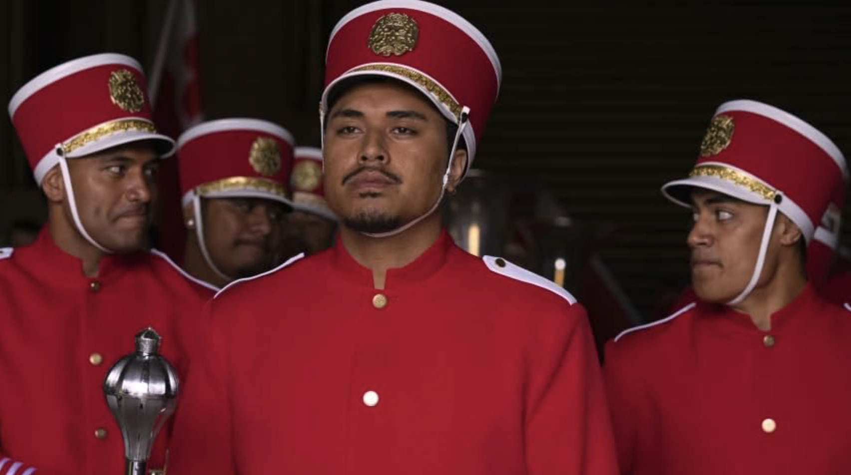 Three men in red band uniforms. Image from 'Red, White and Brass' film.