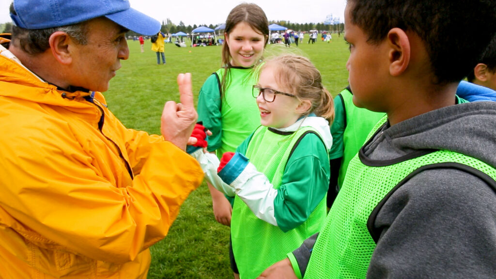 Image from 'Ultimate Citizens' short doc at CSFF 2024 - Jamshid and kids on field